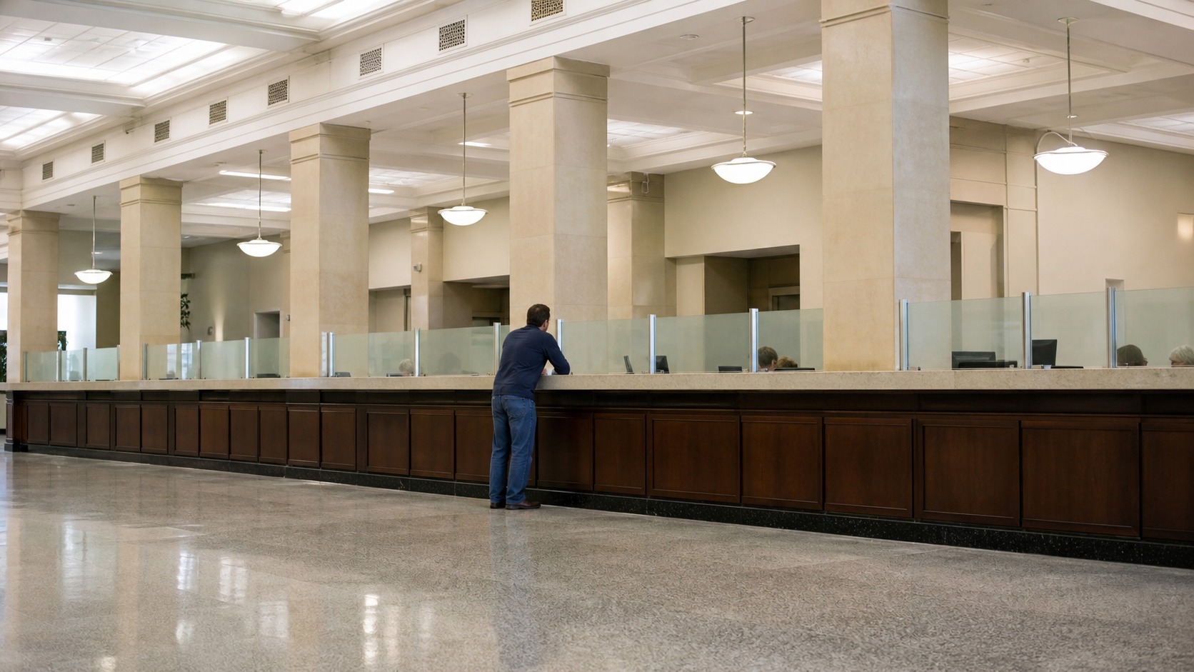 Citizen standing in a large civic office suggesting the scale of government power